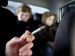 Smoking cigarette in car with children