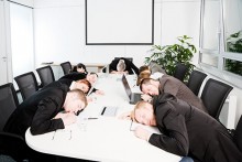 Employees sitting in conference room with heads on table